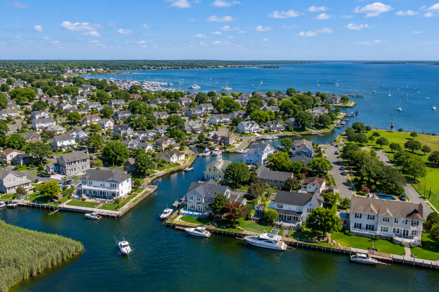 Aerial view of West Sayville overlooking the Great South Bay, where waterfront homes, marinas, and quiet residential neighborhoods reflect the hamlet's deep connection to Long Island's maritime heritage. The scenic South Shore community serves as a gateway to boating, fishing, and nearby Fire Island while offering picturesque bayfront living.