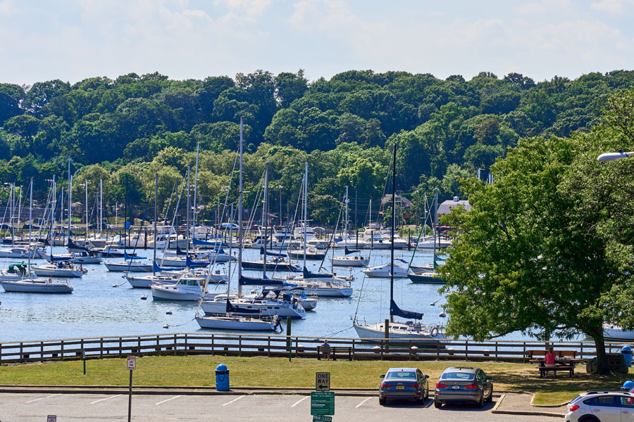 Boats fill the calm waters of Huntington Harbor in Halesite, New York, one of the Town of Huntington's historic waterfront communities on Long Island's North Shore. The protected harbor, marinas, and wooded shoreline reflect Halesite's long-standing connection to recreational boating, sailing, and the region's rich maritime heritage. File photo: John Penney, licensed.