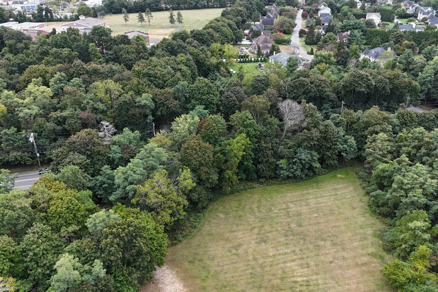 An aerial view over Head of the Harbor reveals the village’s defining mix of wooded land, open fields, and low-density residential neighborhoods. Mature trees and spacious properties help preserve the quiet, rural character of this North Shore community.