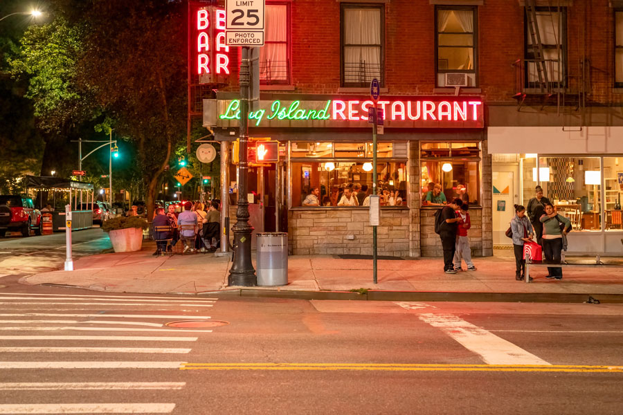 The historic Long Island Bar, a longtime Brooklyn landmark, is illuminated at night at the intersection of Atlantic Avenue and Henry Street. Originally opened in the 1950s, the restored neighborhood restaurant and cocktail bar remains one of Brooklyn's best-known dining destinations, drawing both locals and visitors with its vintage neon signage, classic architecture, and vibrant street-corner atmosphere.