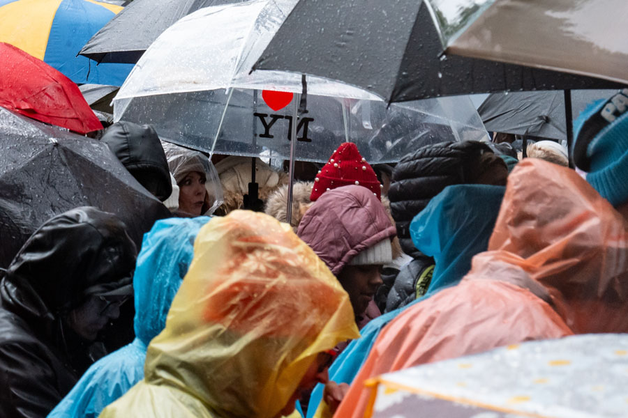 A crowd gathers beneath colorful umbrellas and rain ponchos during wet weather, showing how quickly outdoor plans can change when rain moves across Long Island. Fortunately, the island offers museums, aquariums, theaters, shopping destinations, family entertainment centers, restaurants, and other indoor attractions that can turn a rainy day into an enjoyable outing.