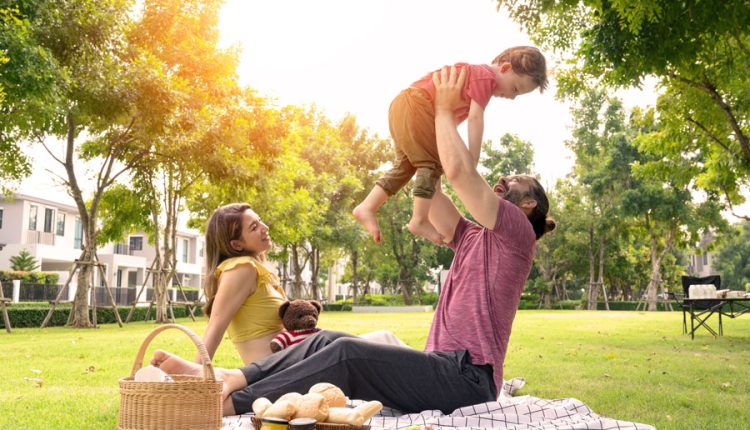 A family enjoys a relaxing afternoon together in a neighborhood park, highlighting the kind of safe, welcoming communities that make Long Island an attractive place to raise children. From highly rated school districts and family-friendly parks to year-round activities and strong community ties, many Long Island towns offer an excellent quality of life for growing families. File photo: Pratchaya Lee, licensed.