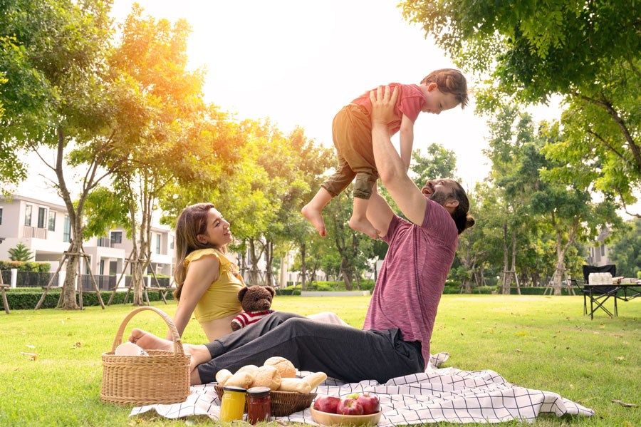 A family enjoys a relaxing afternoon together in a neighborhood park, highlighting the kind of safe, welcoming communities that make Long Island an attractive place to raise children. From highly rated school districts and family-friendly parks to year-round activities and strong community ties, many Long Island towns offer an excellent quality of life for growing families. File photo: Pratchaya Lee, licensed.