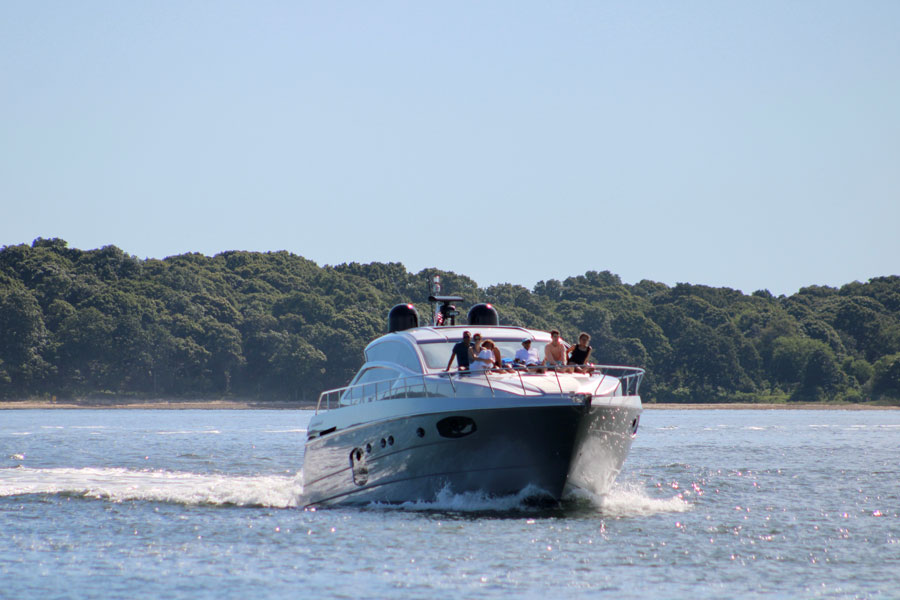 A recreational motor yacht cruises across the calm waters of Shelter Island Sound near Shelter Island, showcasing the scenic boating opportunities that make the East End one of Long Island's premier destinations for sailing, fishing, and waterfront recreation. The protected waters between the North Fork and Shelter Island are especially popular with boaters during the summer months. File photo: Wirestock Creators, licensed.