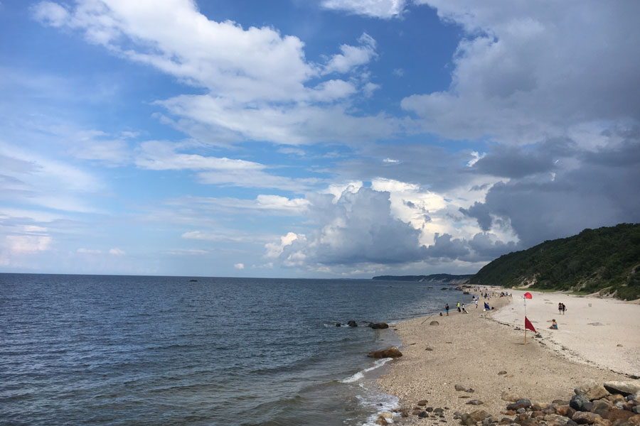 Visitors enjoy the beach at Wildwood State Park along the Long Island Sound in Wading River. Known for its scenic shoreline, wooded bluffs, and peaceful setting, the state park offers opportunities for swimming, beachcombing, camping, fishing, hiking, and enjoying panoramic views of Long Island's North Shore. File photo: Joe Trentacosti, licensed.