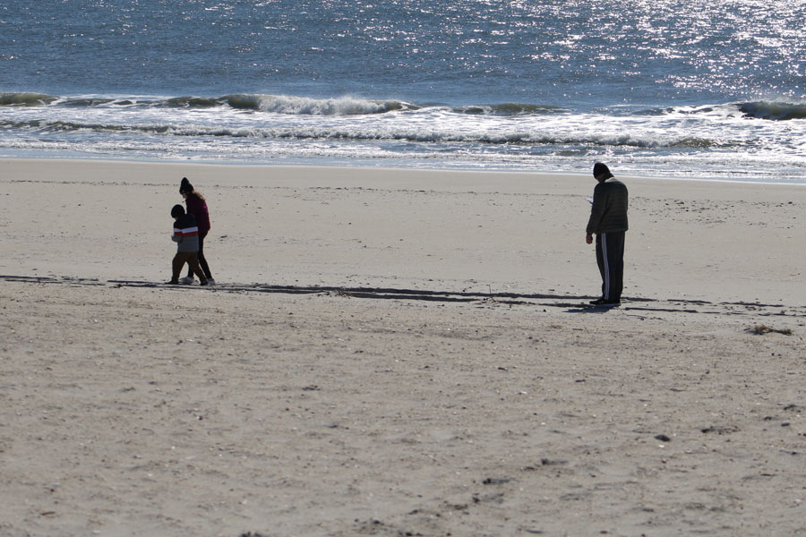 Visitors enjoy a peaceful winter walk along a Long Island beach after the summer crowds have disappeared. Many public beaches remain open year-round, offering opportunities for beachcombing, photography, birdwatching, fishing, and quiet walks along the shoreline even during the colder months. File photo: Jaclyn Vernace, licensed.