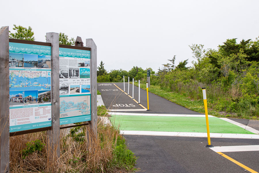 Informational signs mark the beginning of a paved multi-use trail at Captree State Park, part of Long Island's growing network of scenic bike paths. From beachfront routes and state parks to rail trails and nature preserves, cyclists can explore miles of paved pathways while enjoying some of the island's most beautiful coastal landscapes. File photo: WoodysPhotos, licensed.