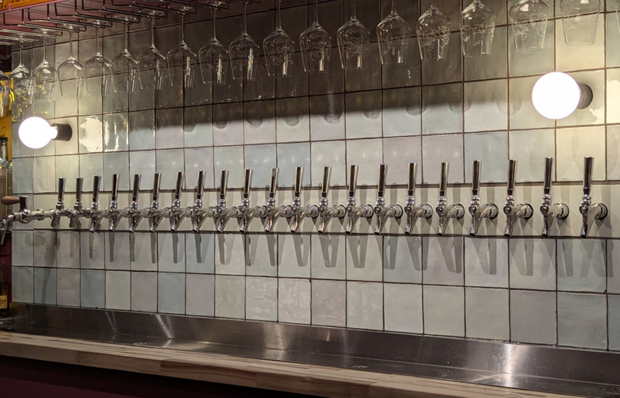 Rows of polished draft beer taps await visitors inside a modern Long Island brewery taproom, reflecting the region's thriving craft beer scene and growing number of independent breweries. Many breweries across Long Island feature tasting rooms where guests can sample seasonal releases, flagship beers, and limited-edition brews in a relaxed setting.