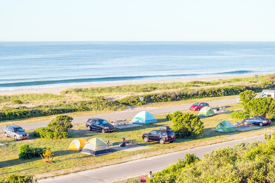 Tents and RVs line the oceanfront campground at Hither Hills State Park in Montauk, one of Long Island's most sought-after camping destinations. The campground offers direct access to the Atlantic Ocean, making it a favorite for beachgoers, anglers, and families looking to experience overnight camping along the South Fork.