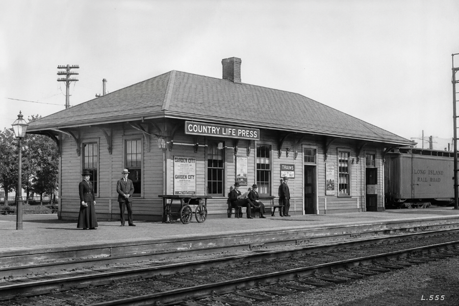 Recreated black-and-white illustration based on a historic photograph believed to depict Country Life Press station in Garden City, New York, circa 1919. The original image, identified by the archival marking "L.555" and widely circulated among Long Island Rail Road historians, appears to originate from an early Long Island Rail Road photographic archive. This recreation was created to illustrate the station that took its name from the nearby Country Life Press publishing complex built by Doubleday, Page & Company.