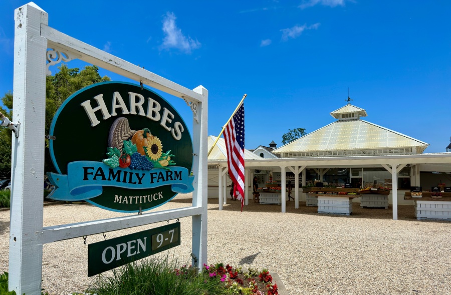 A sign for Harbes Family Farm stands beside the farm’s roadside produce market in Mattituck, New York. The popular North Fork agricultural destination offers seasonal produce, local foods, family activities, and a direct connection to Long Island’s farming heritage.