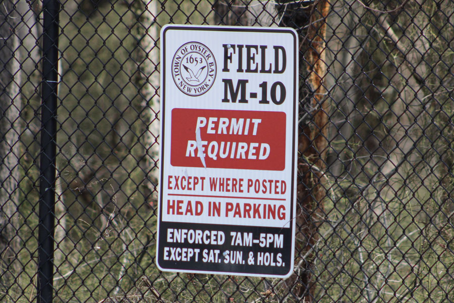 A permit-required parking sign stands near TOBAY Beach in the Town of Oyster Bay, reminding visitors that certain parking areas require a valid town permit during designated hours. Many Long Island beaches have seasonal parking regulations, resident permit requirements, or activity-specific permits that vary by municipality. File photo: Jaclyn Vernace, licensed.