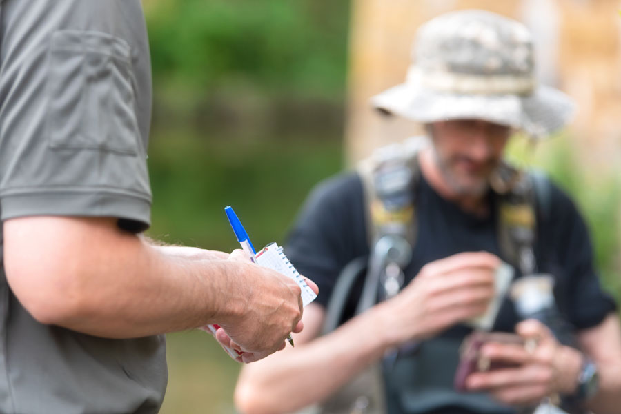A fisheries officer checks an angler's fishing credentials, helping ensure compliance with New York's licensing requirements and conservation regulations. Before fishing on Long Island, anglers should make sure they have the appropriate freshwater license or saltwater registration for the waters they plan to fish. File photo: David Herraez Calzada, licensed.