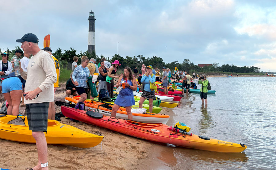 Kayakers gather along the shoreline near the Fire Island Lighthouse before launching onto the calm waters surrounding Fire Island National Seashore. From protected bays and tidal creeks to scenic harbors and coastal waterways, Long Island offers exceptional kayaking opportunities for paddlers of all skill levels. File photo: WoodysPhotos, licensed.