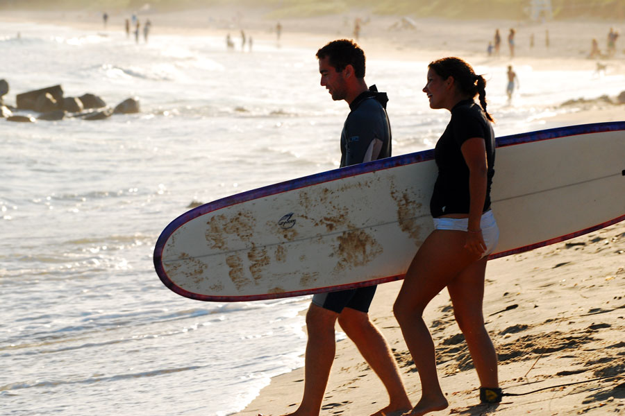 A young couple carries their surfboards toward the Atlantic Ocean at Montauk on a summer evening, preparing to catch the next set of waves. Long regarded as Long Island's premier surfing destination, Montauk attracts surfers year-round with its consistent swells, iconic breaks, and vibrant surf culture. File photo: James Kirkikis, licensed.