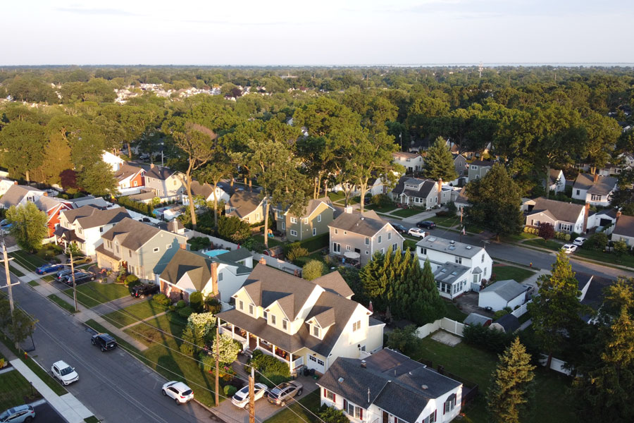 An aerial view of a quiet Long Island residential neighborhood showcases the tree-lined streets, well-kept homes, and suburban communities that define much of Nassau and Suffolk counties. From historic villages to modern hamlets, Long Island's towns offer a diverse mix of neighborhoods, local businesses, parks, and family-friendly communities. File photo: Francesco Joesph, licensed.