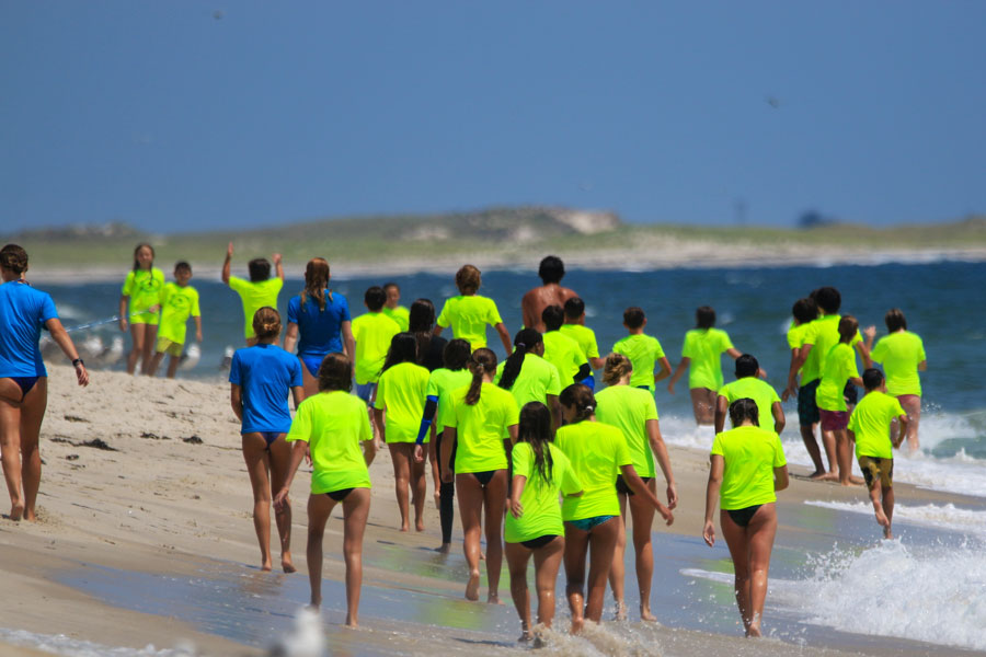 Children participating in Bunger Surf Camp walk along the shoreline at Gilgo Beach on Long Island on July 25, 2023. The oceanfront area is known for surfing, surf fishing and its relatively undeveloped barrier-beach setting along the Atlantic Ocean.