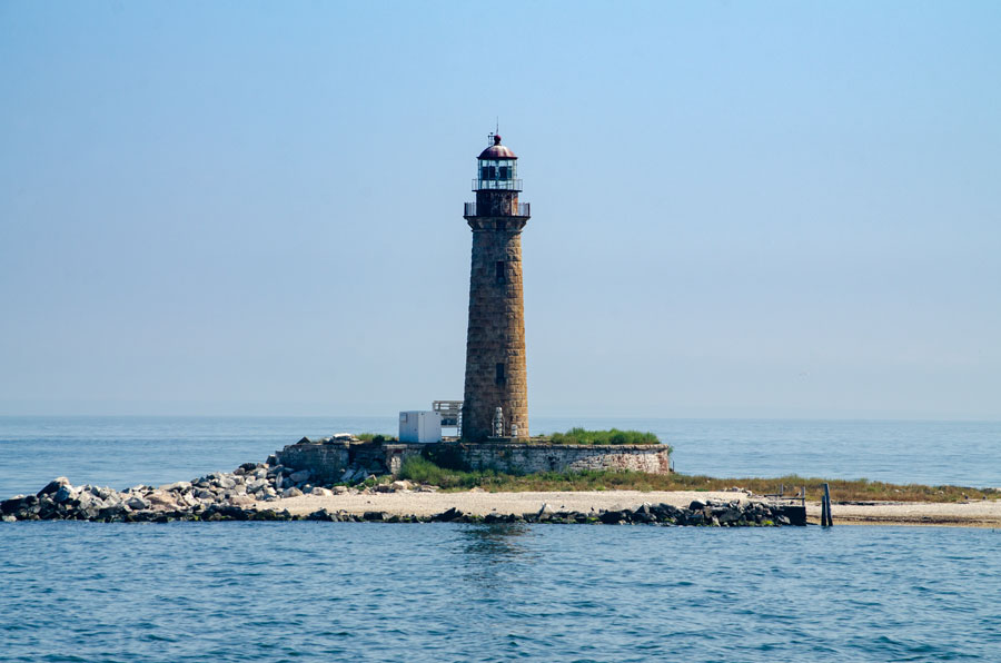 Little Gull Island Lighthouse rises from a rocky islet in Long Island Sound, marking the challenging waters of The Race between Plum Island and Fishers Island. The historic granite tower remains an active navigational aid in Suffolk County, New York.