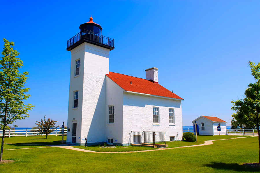 Sands Point Lighthouse stands on the northern tip of the Cow Neck Peninsula in Sands Point, Long Island, overlooking Long Island Sound. Built in 1809, the historic white-brick lighthouse and attached keeper’s residence are preserved as an important maritime landmark, although the privately owned property is not open for regular public tours.