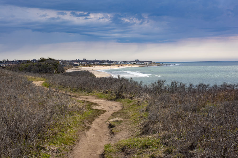 A scenic trail winds through the coastal landscape of Shadmoor State Park in Montauk, overlooking the Atlantic Ocean and sandy shoreline. The 99-acre preserve is known for its ocean bluffs, walking trails, coastal habitat and expansive views along Long Island’s South Fork.