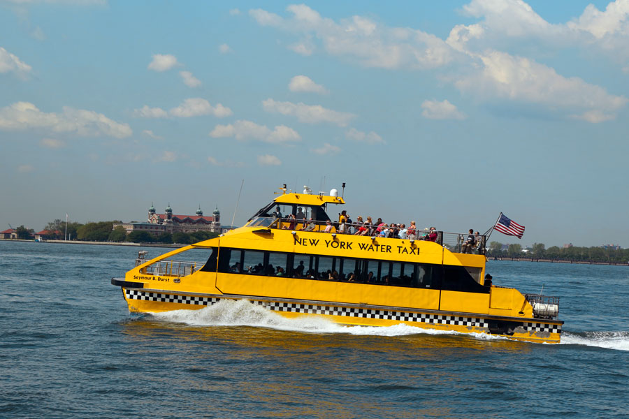 NEW YORK -AUGUST 6: New York City Water Taxi in the front of Ellis Island on August 6, 2013. NYC Water Taxi has been servicing NYC commuters since 2002