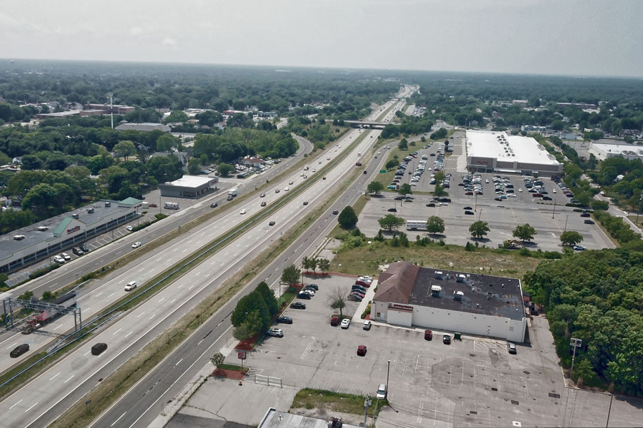 Aerial view of Sunrise Highway passing through Patchogue, Long Island, with commercial properties, residential neighborhoods and tree-lined communities stretching across the surrounding area. The major east-west roadway is one of Suffolk County’s primary transportation corridors, connecting communities across central and eastern Long Island. File photo: Oleh Korotkov, licensed.