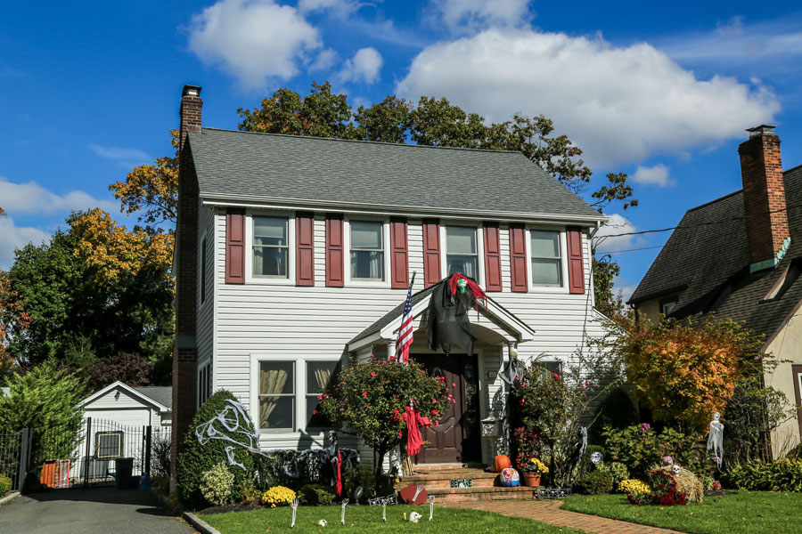 A home in Oceanside displays an American flag and Halloween decorations in this November 2016 photograph. Nassau County’s median single-family sale price reached $860,000 in September 2026, while Suffolk County’s reached $740,000, according to OneKey MLS. Prices rose from a year earlier in both counties as single-family inventory declined.