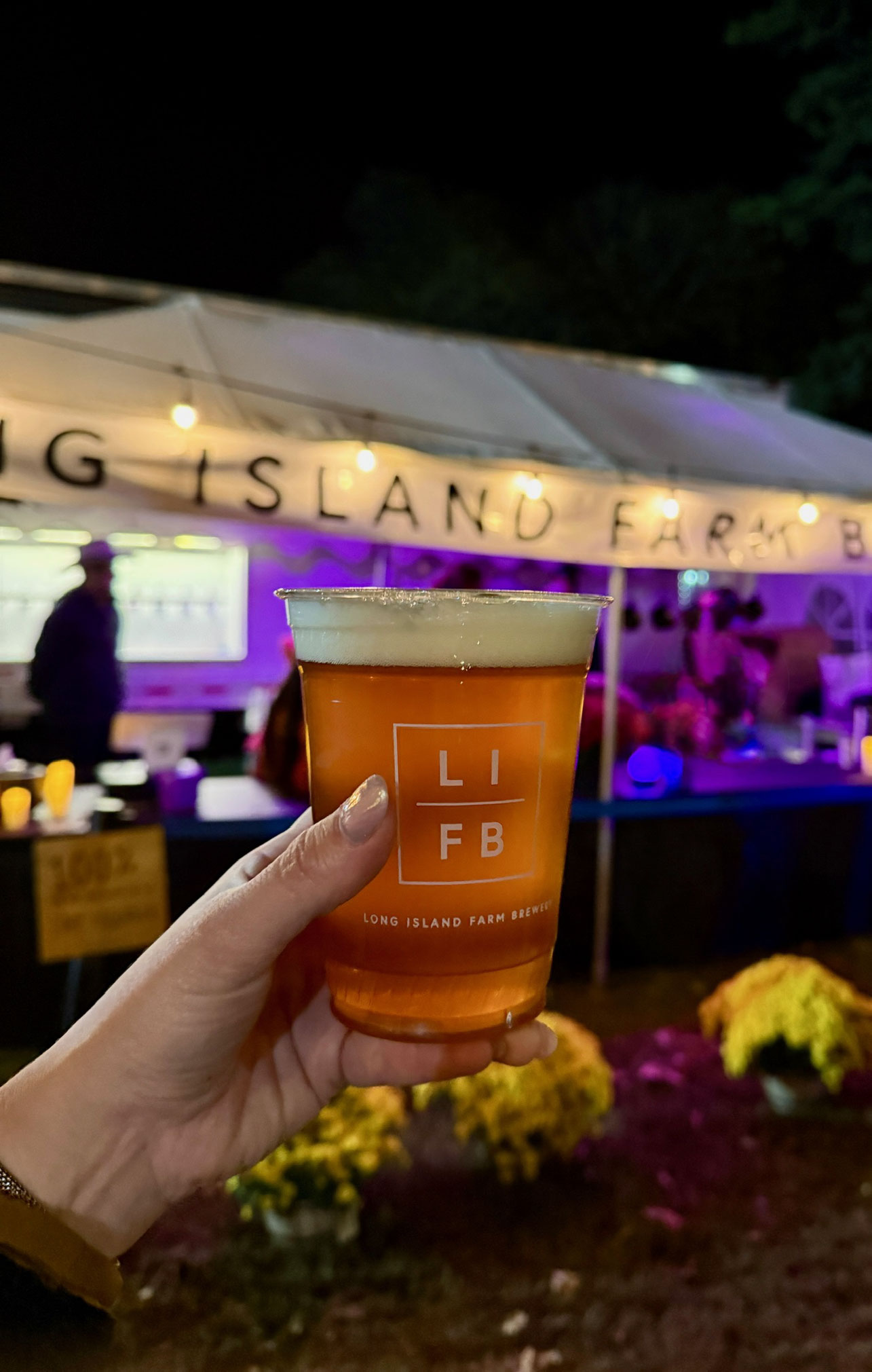 A visitor holds a cup of beer from Long Island Farm Brewery, which donates beer for the Spooky Walk fundraising event in Center Moriches. Beyond the haunted trail, attendees can enjoy food, refreshments, music and a festive community atmosphere while supporting Camp Pa-Qua-Tuck. Photo courtesy of Camp Pa-Qua-Tuck Fundraisers.