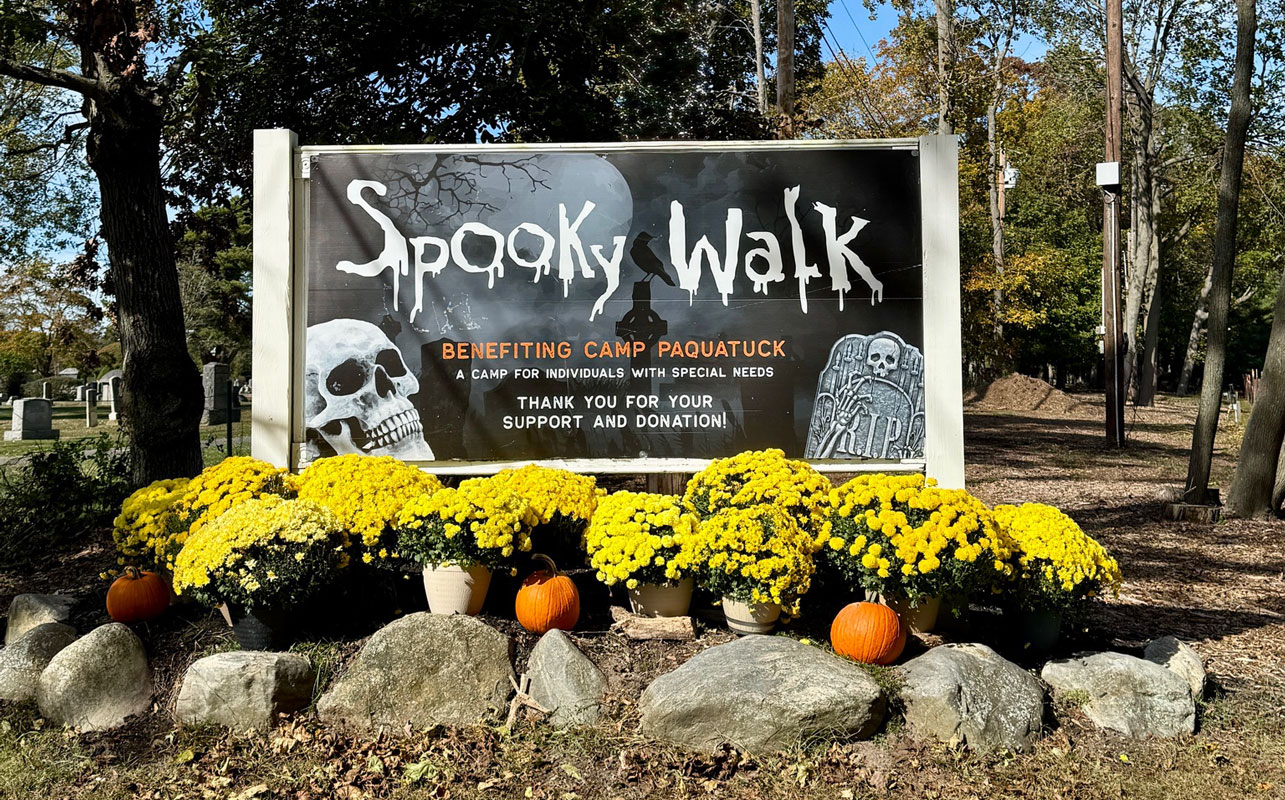 The entrance to Spooky Walk at Camp Pa-Qua-Tuck in Center Moriches is decorated with pumpkins and colorful chrysanthemums for the annual Halloween fundraiser. Returning October 16, 2026, the volunteer-operated haunted attraction raises money to support recreational programs for children and adults with special needs. Photo courtesy of Camp Pa-Qua-Tuck Fundraisers.
