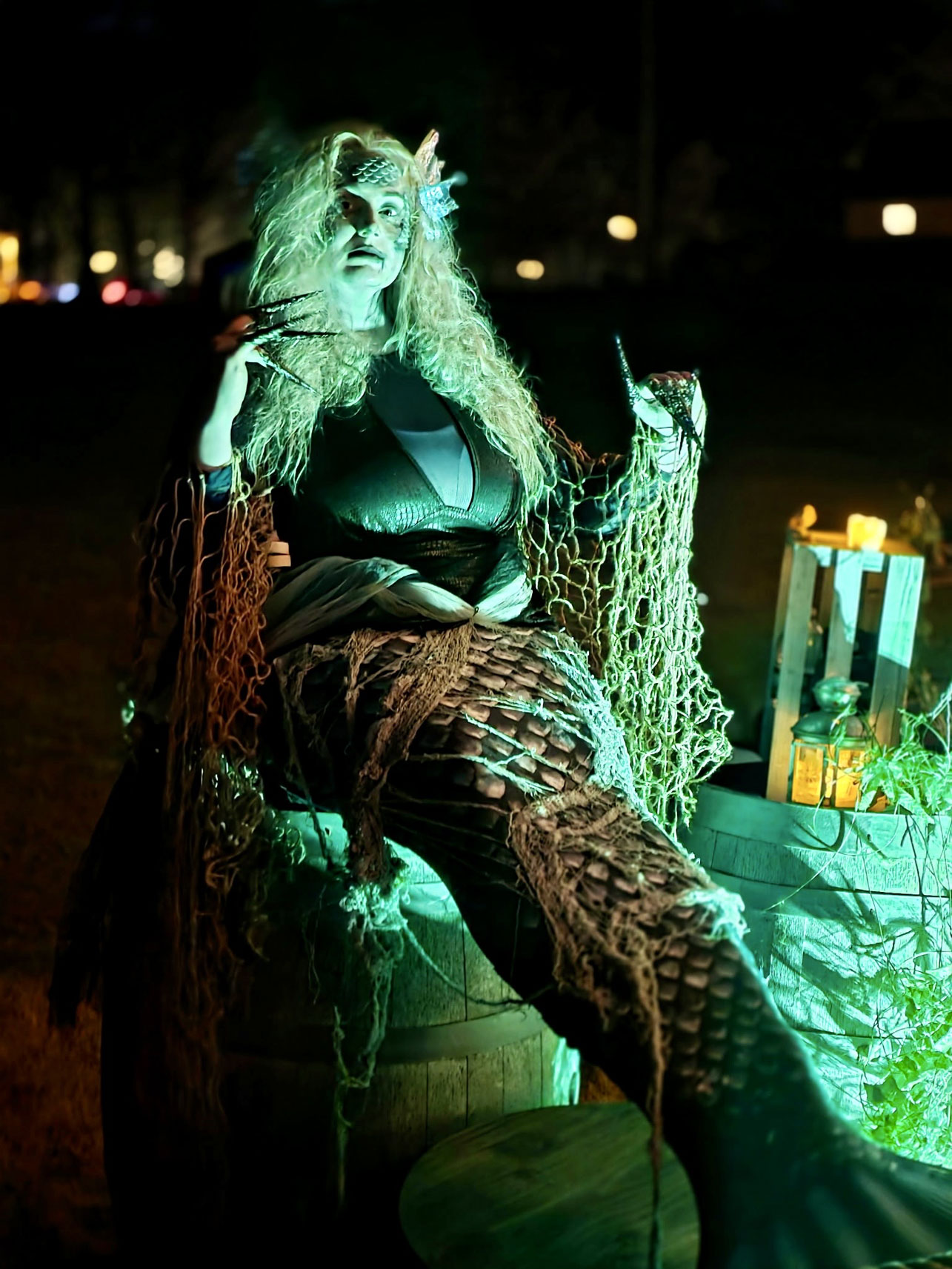 An elaborately costumed mermaid-like character illuminated by eerie green lighting brings a supernatural element to Spooky Walk at Camp Pa-Qua-Tuck. The annual attraction incorporates imaginative costumes, theatrical performances and detailed scenery across multiple themed environments. Photo courtesy of Camp Pa-Qua-Tuck Fundraisers.