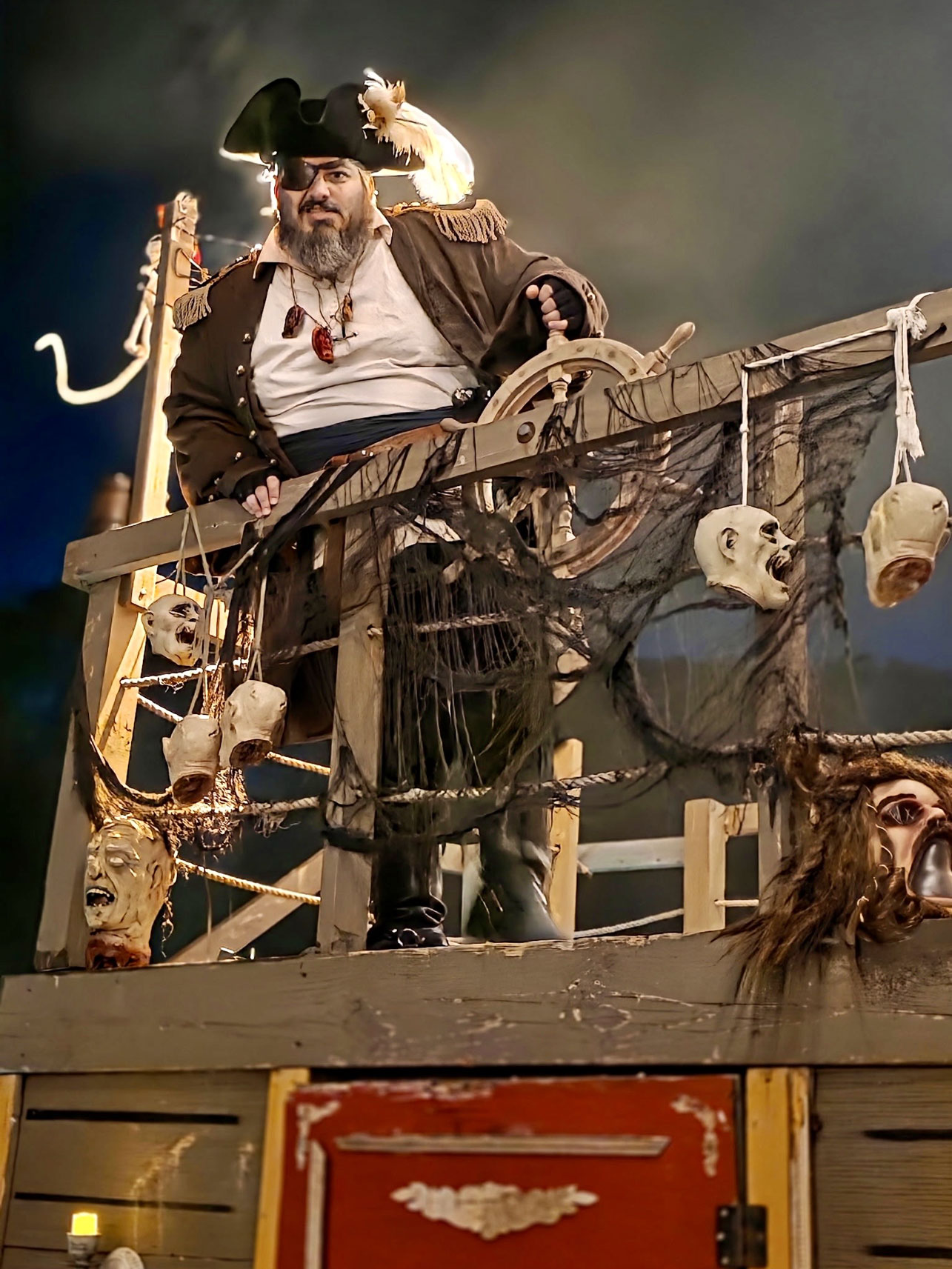 A pirate captain stands at the helm of a decorated ship surrounded by eerie theatrical props during Spooky Walk in Center Moriches. The Pirates is among eight themed attractions announced for the 2026 event, which returns October 16, 17, 23 and 24 to benefit Camp Pa-Qua-Tuck. Photo courtesy of Camp Pa-Qua-Tuck Fundraisers.
